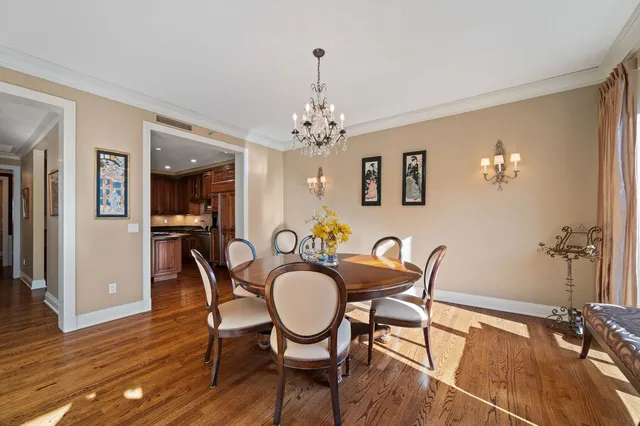 a dining room with furniture a chandelier and wooden floor