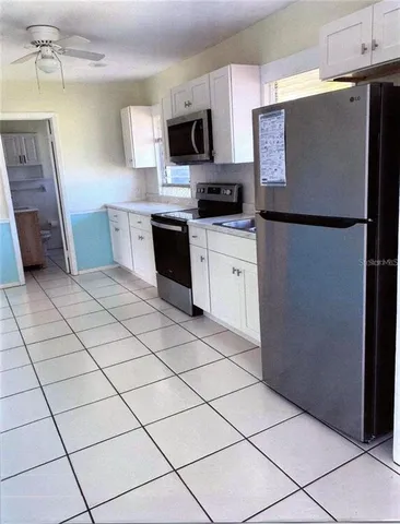 a kitchen with stainless steel appliances a refrigerator sink and microwave