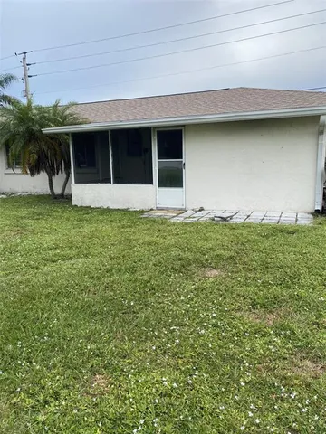 a backyard of a house with large trees and plants