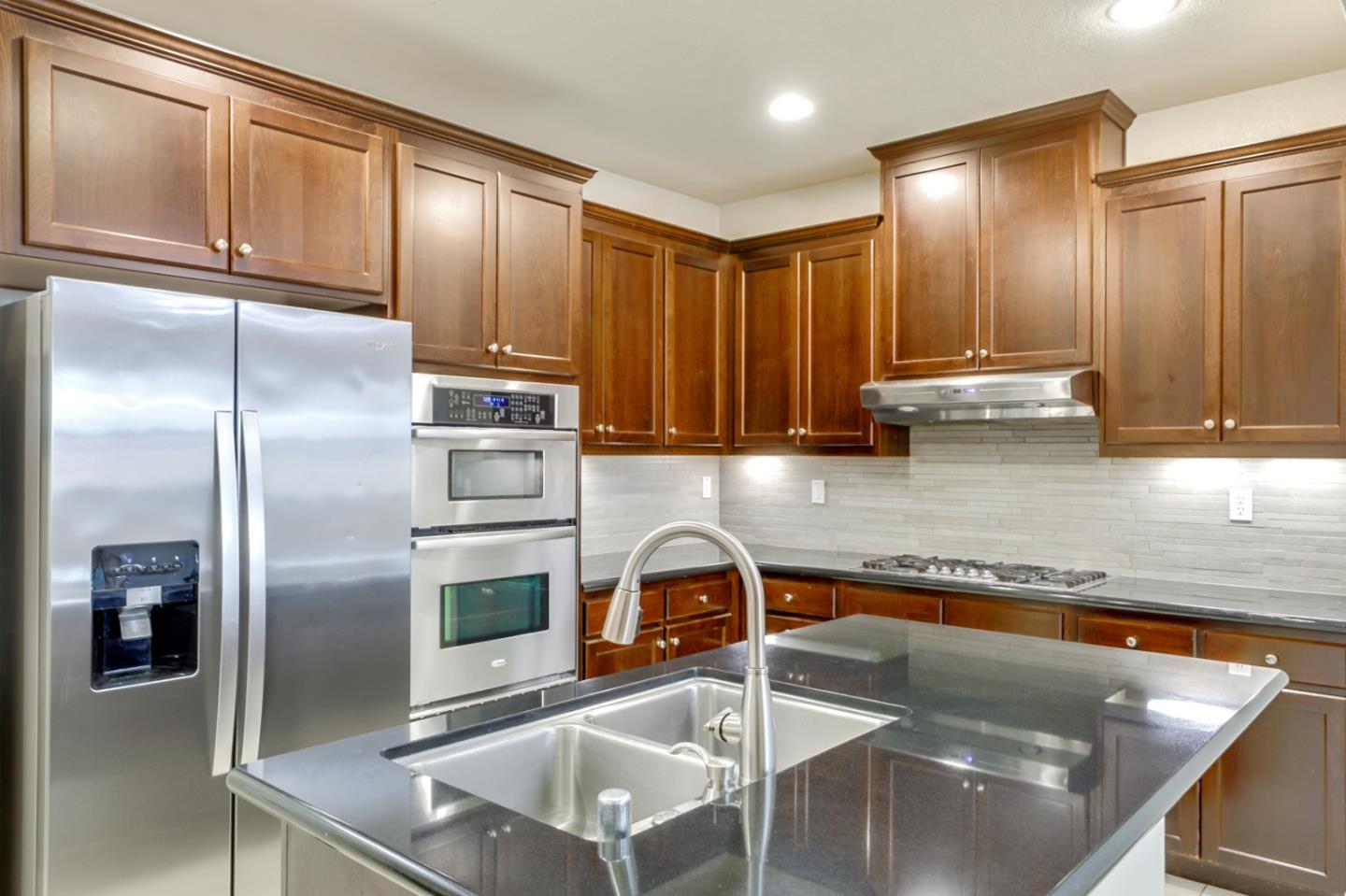 5090 Fioli Loop San Ramon, CA 94582 - Photo 5 of 36 a kitchen with granite countertop stainless steel appliances and a counter top space