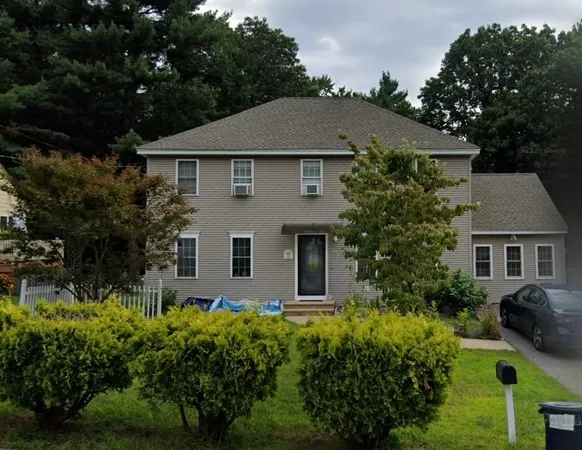 front view of house with a yard and potted plants