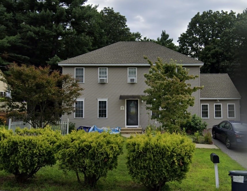 front view of house with a yard and potted plants