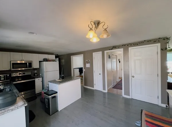 a view of a kitchen with a stove wooden cabinet and a refrigerator