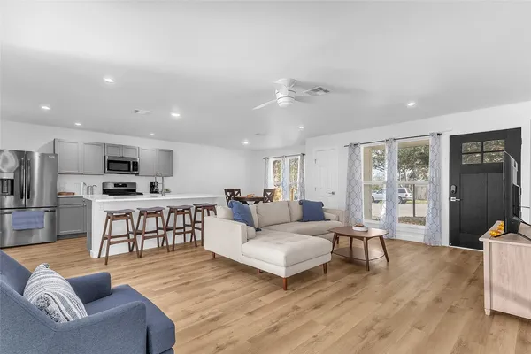 a living room with furniture and view of kitchen