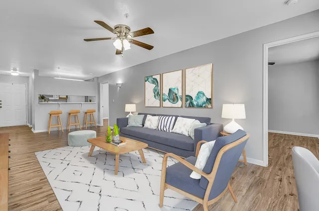 a living room with furniture and a view of kitchen