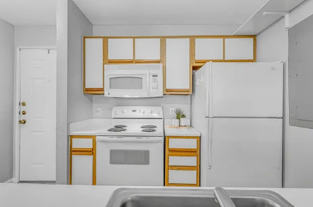 a kitchen with a refrigerator sink stove and microwave