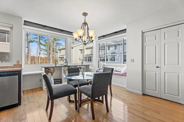 a dining room with furniture a chandelier and wooden floor