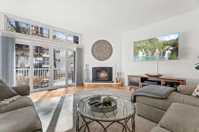 a living room with furniture a fireplace and a floor to ceiling window