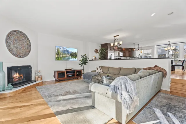 a living room with furniture a fireplace and a chandelier