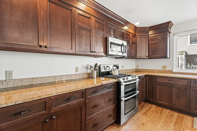 a kitchen with stainless steel appliances granite countertop a sink a stove and cabinets