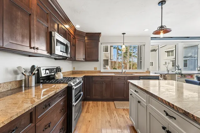 a kitchen with stainless steel appliances granite countertop a sink stove and microwave
