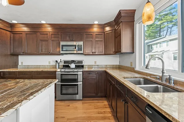 a kitchen with granite countertop a sink and a stove top oven