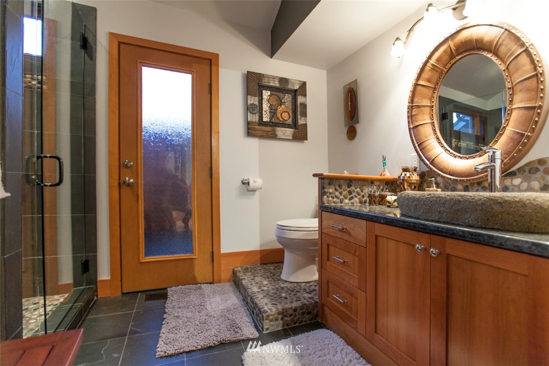 804 Fieldston Road Bellingham, WA 98225 - Photo 23 of 40 a bathroom with a granite countertop sink mirror vanity and toilet