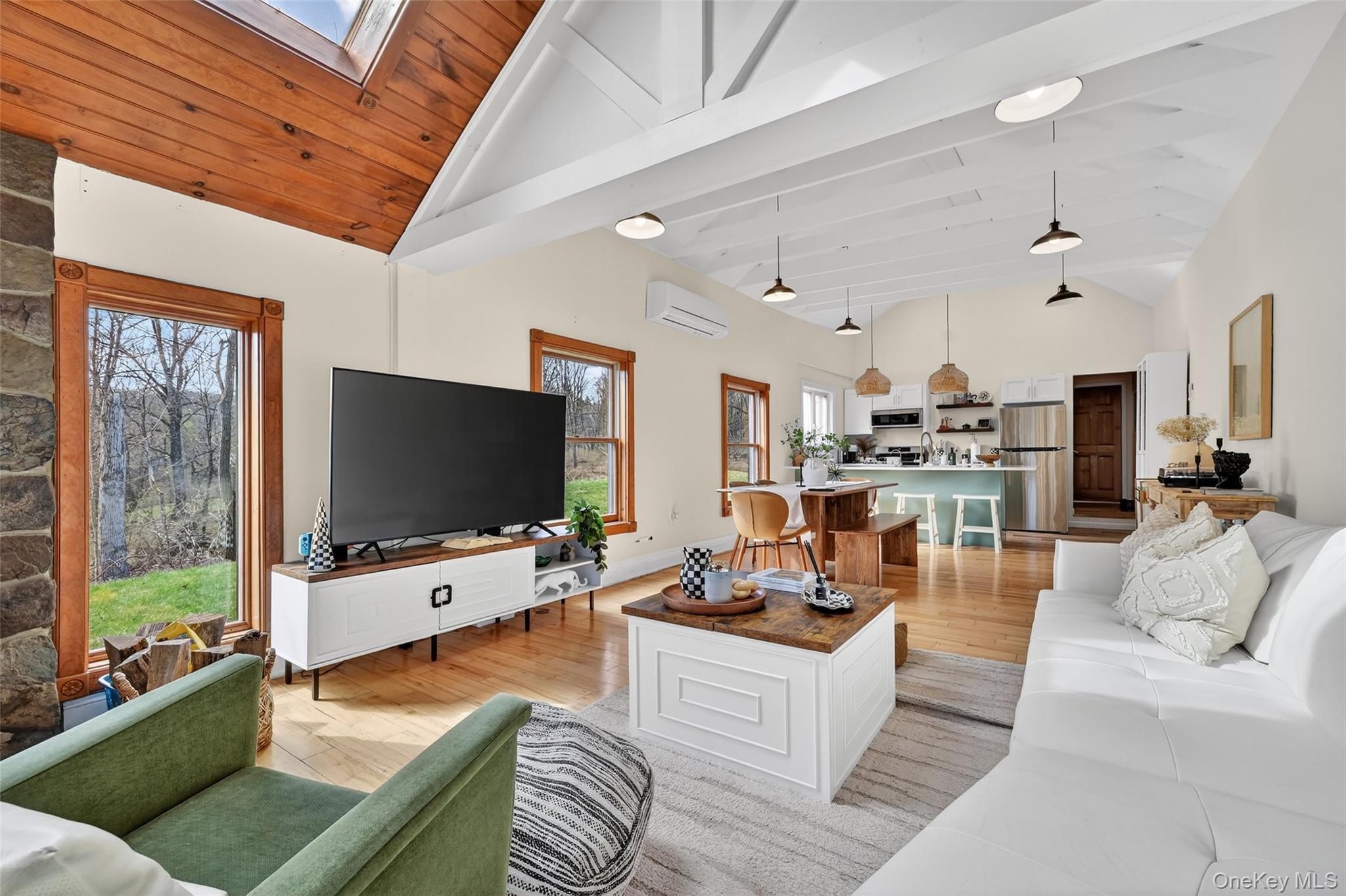 96 Lower Wisner Road Warwick, NY 10990 - Photo 15 of 34 Open concept living area featuring vaulted ceilings with exposed beams, wood-finish flooring, and a stone-clad fireplace
