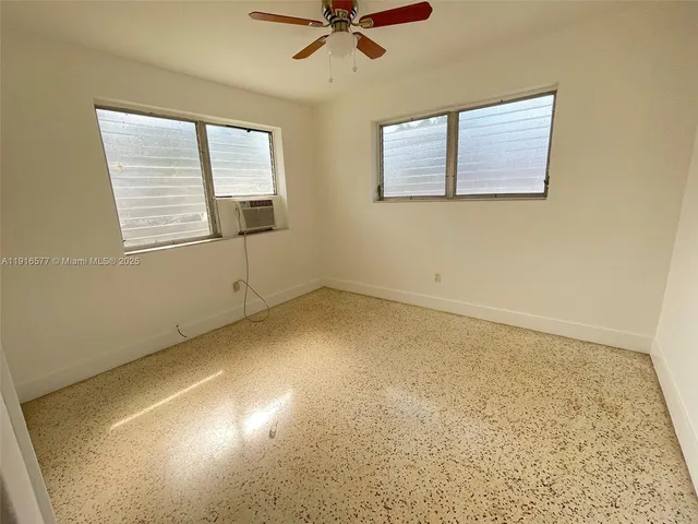 an empty room with a window and a ceiling fan