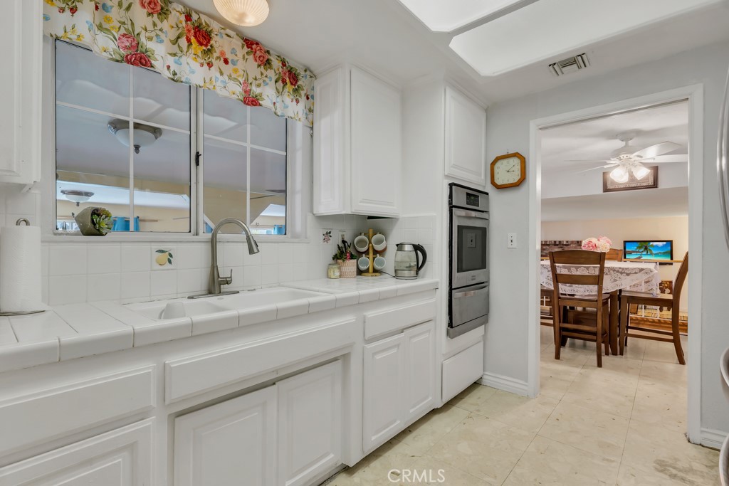 14024 Tyler Street Sylmar, CA 91342 - Photo 16 of 50 a kitchen with cabinets and chairs