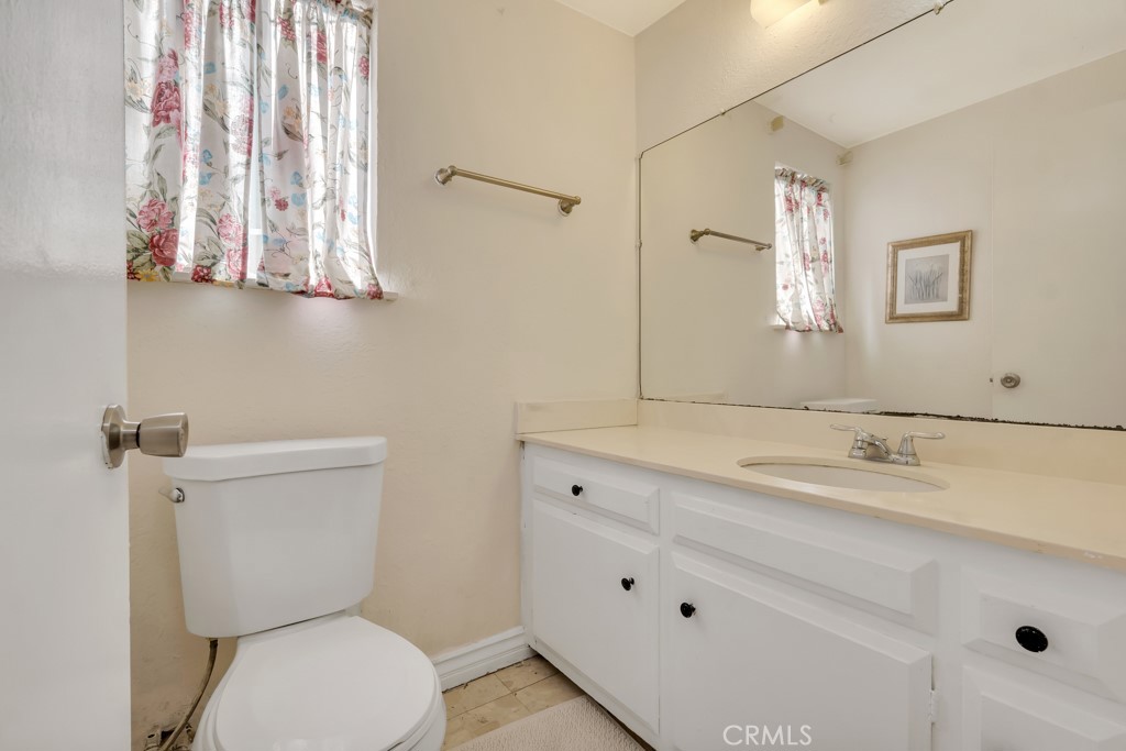 14024 Tyler Street Sylmar, CA 91342 - Photo 21 of 50 a bathroom with a granite countertop toilet sink and mirror