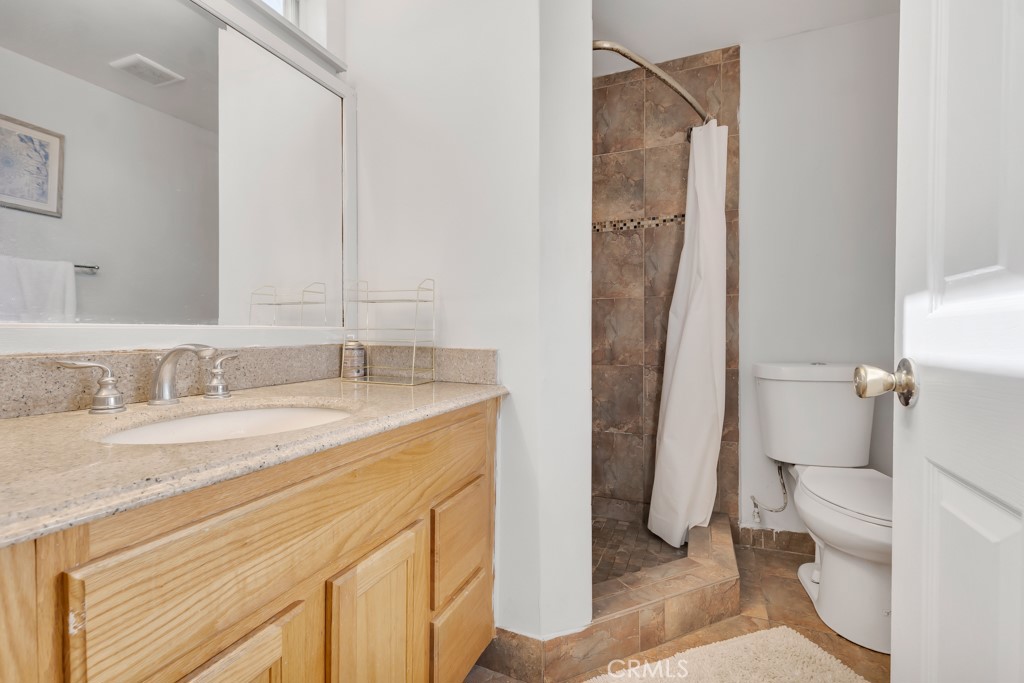 14024 Tyler Street Sylmar, CA 91342 - Photo 26 of 50 a bathroom with a granite countertop sink and a mirror