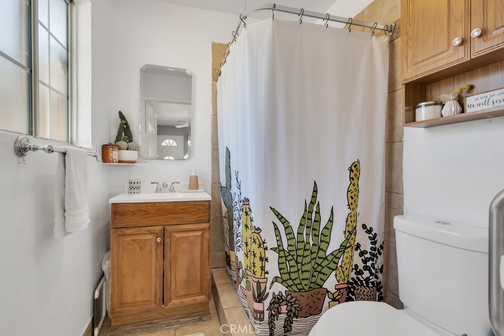 14024 Tyler Street Sylmar, CA 91342 - Photo 41 of 50 a bathroom with a granite countertop sink a toilet and shower