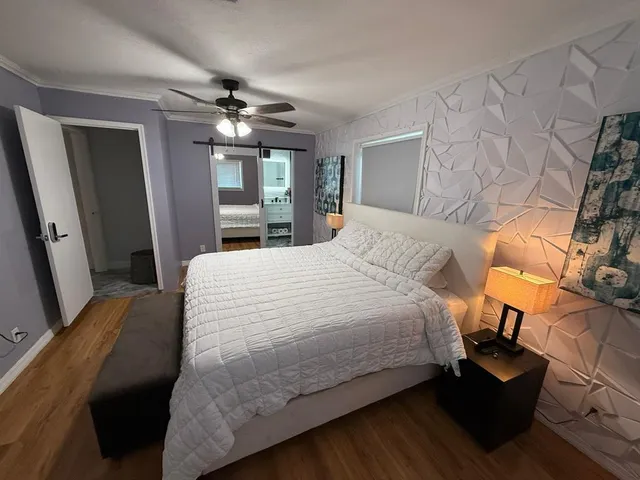 a view of kitchen with stainless steel appliances wooden floor dining table and chairs