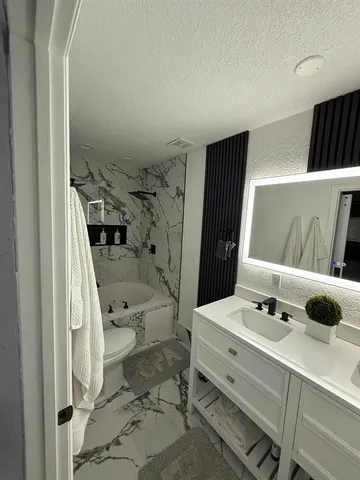 a kitchen with stainless steel appliances kitchen island granite countertop a table chairs in it and wooden floors