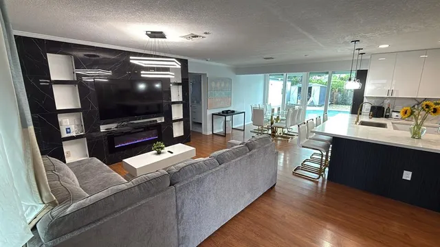 a living room with stainless steel appliances furniture cabinets and a kitchen view