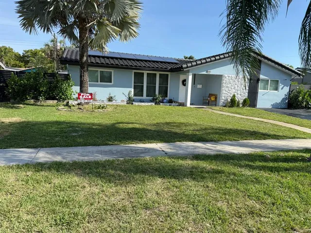 a front view of house with a garden and patio