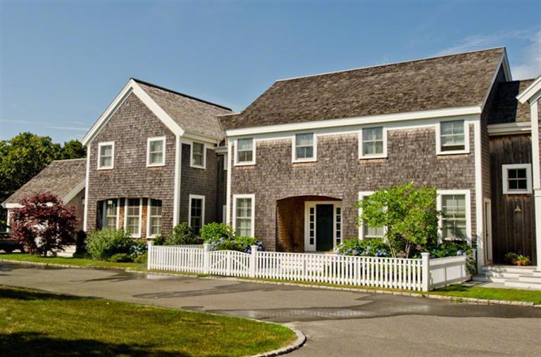 a front view of a house with a garden and plants