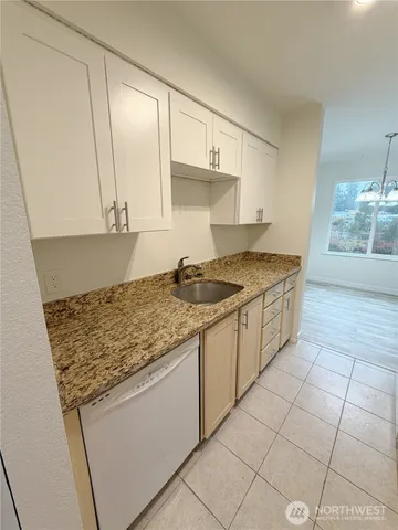 a kitchen with granite countertop a sink a stove and cabinets