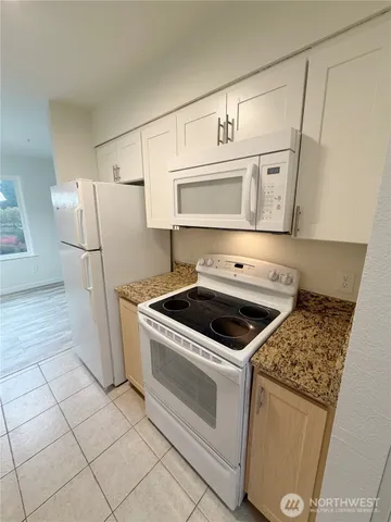 a kitchen with white cabinets and white appliances