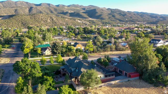 426 West Center Street Parowan, UT 84761 - Photo 104 of 107 Expansive property featuring a multi-level residence with a distinctive roofline, detached garage with red doors, and mature trees