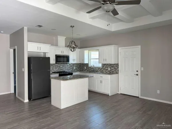 a kitchen with stainless steel appliances a refrigerator sink and white cabinets