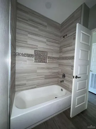 an empty room with wooden floor and fan