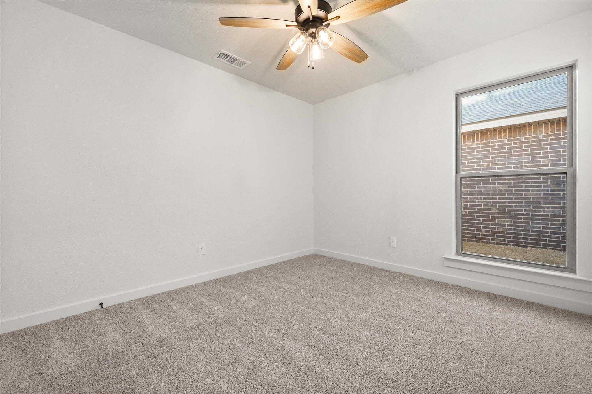 3113 140th Street Lubbock, TX 79423 - Photo 17 of 22 an empty room with a window and a fan