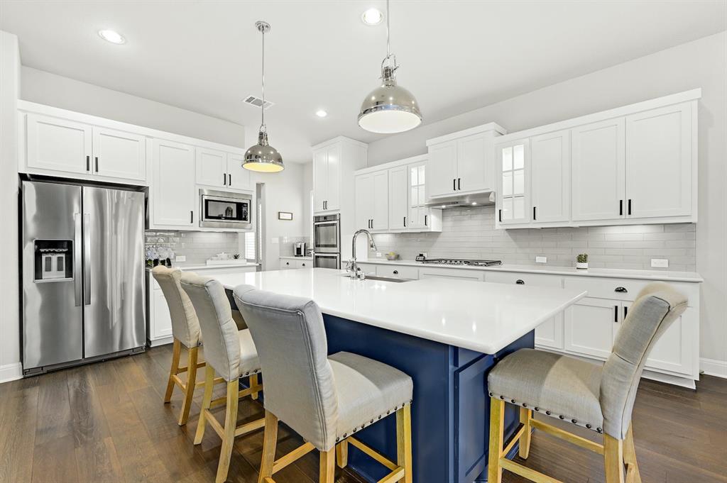 629 Germander Road Leander, TX 78641 - Photo 9 of 32 Culinary aspirations find their perfect setting in this chef's kitchen featuring a large central island with seating.
