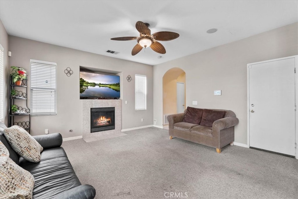 1474 Albillo Loop Perris, CA 92571 - Photo 8 of 35 a living room with furniture a fireplace and a chandelier