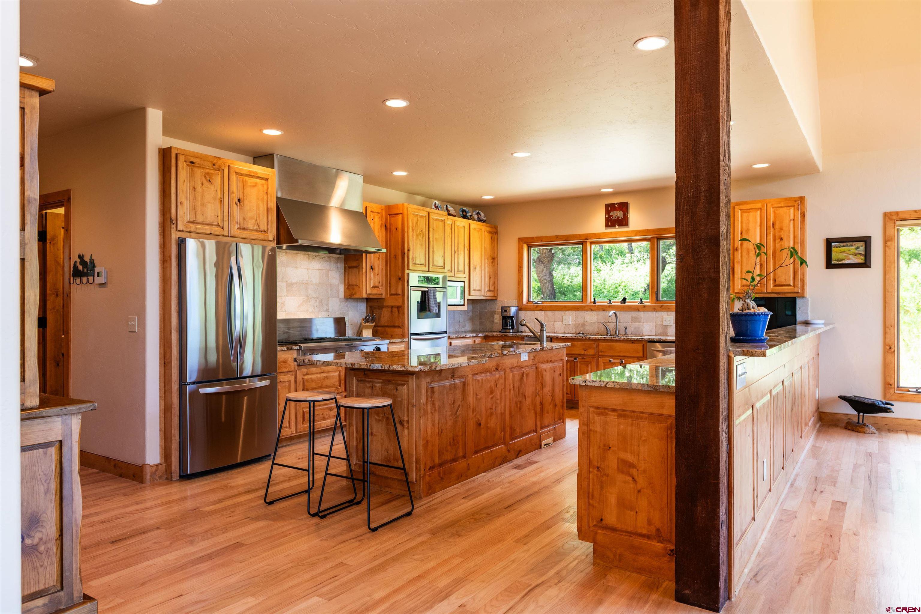 2550 Destination Ranch Road Durango, CO 81301 - Photo 16 of 45 a kitchen with stainless steel appliances granite countertop a refrigerator a stove top oven and wooden floors