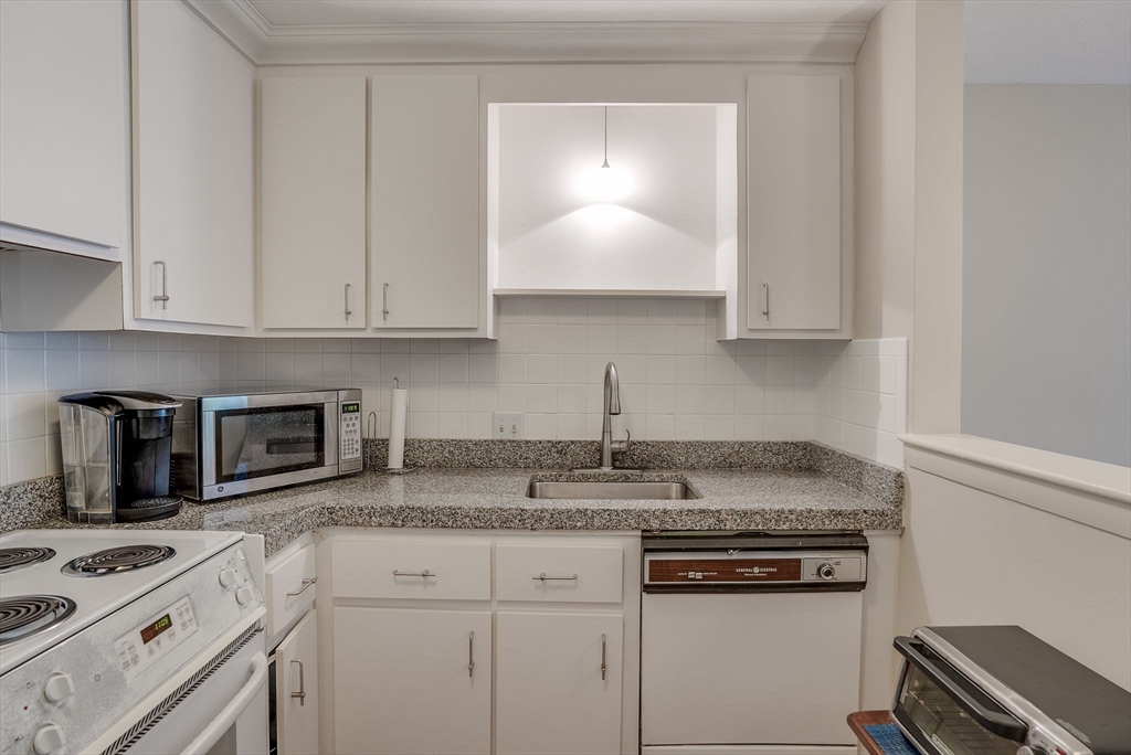 36 Whitman Road, Unit 24 Waltham, MA 02453 - Photo 7 of 14 a kitchen with granite countertop a stove sink and cabinets