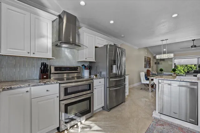 a kitchen with stainless steel appliances a stove a sink and a refrigerator