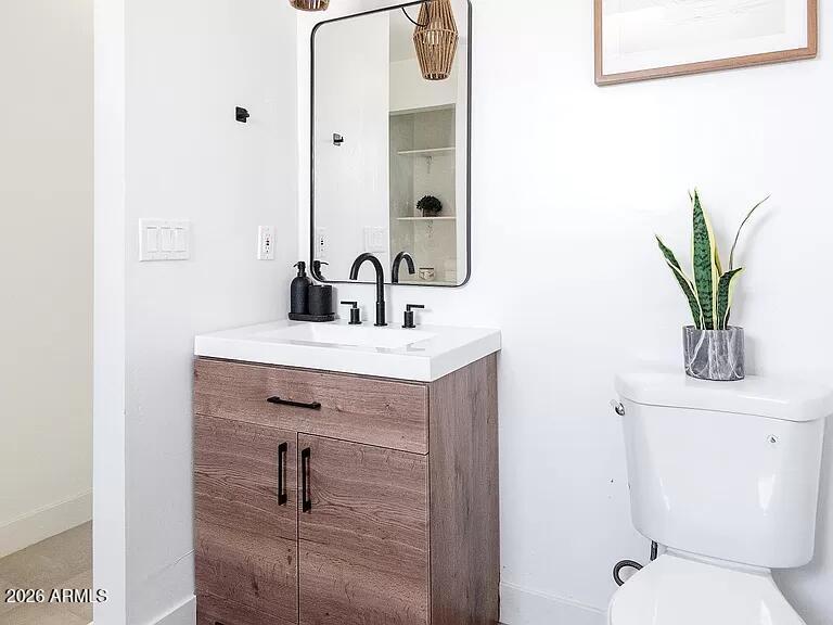 2915 West Griswold Road Phoenix, AZ 85051 - Photo 11 of 17 a bathroom with a toilet a sink and mirror