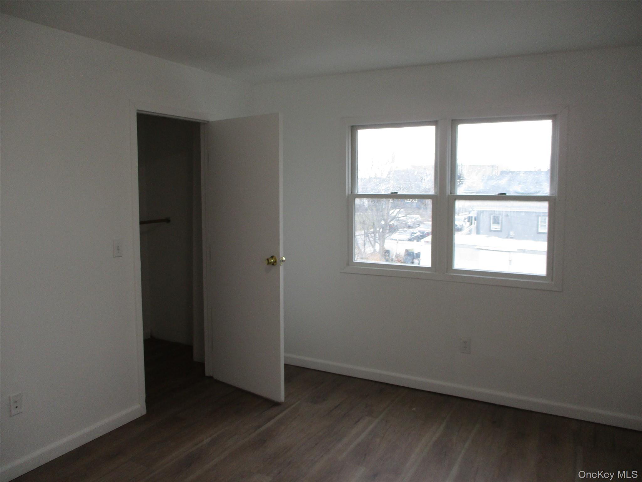 94 Roger Avenue Inwood, NY 11096 - Photo 13 of 19 an empty room with wooden floor and a window