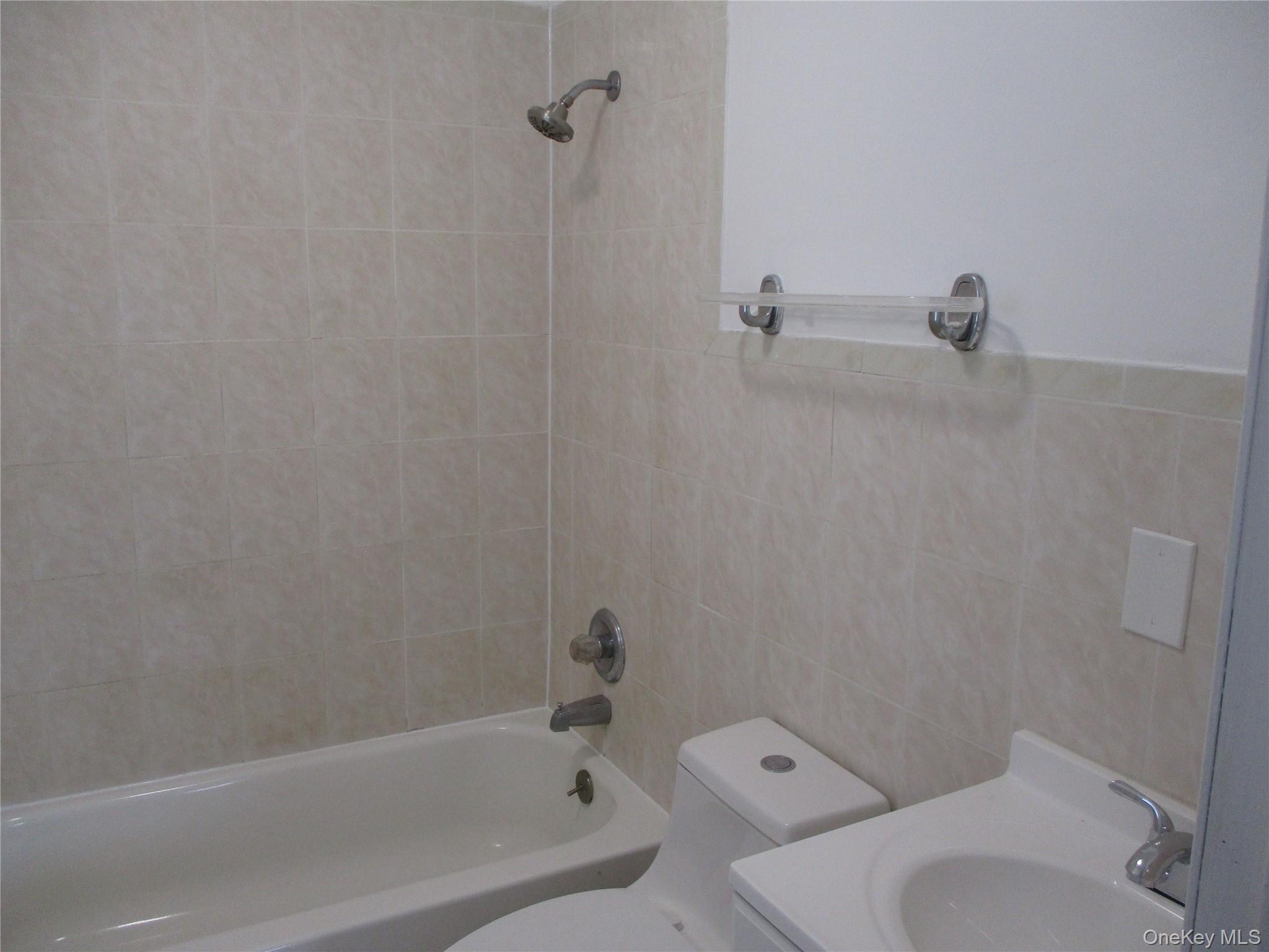94 Roger Avenue Inwood, NY 11096 - Photo 14 of 19 a white bath tub sitting next to a toilet