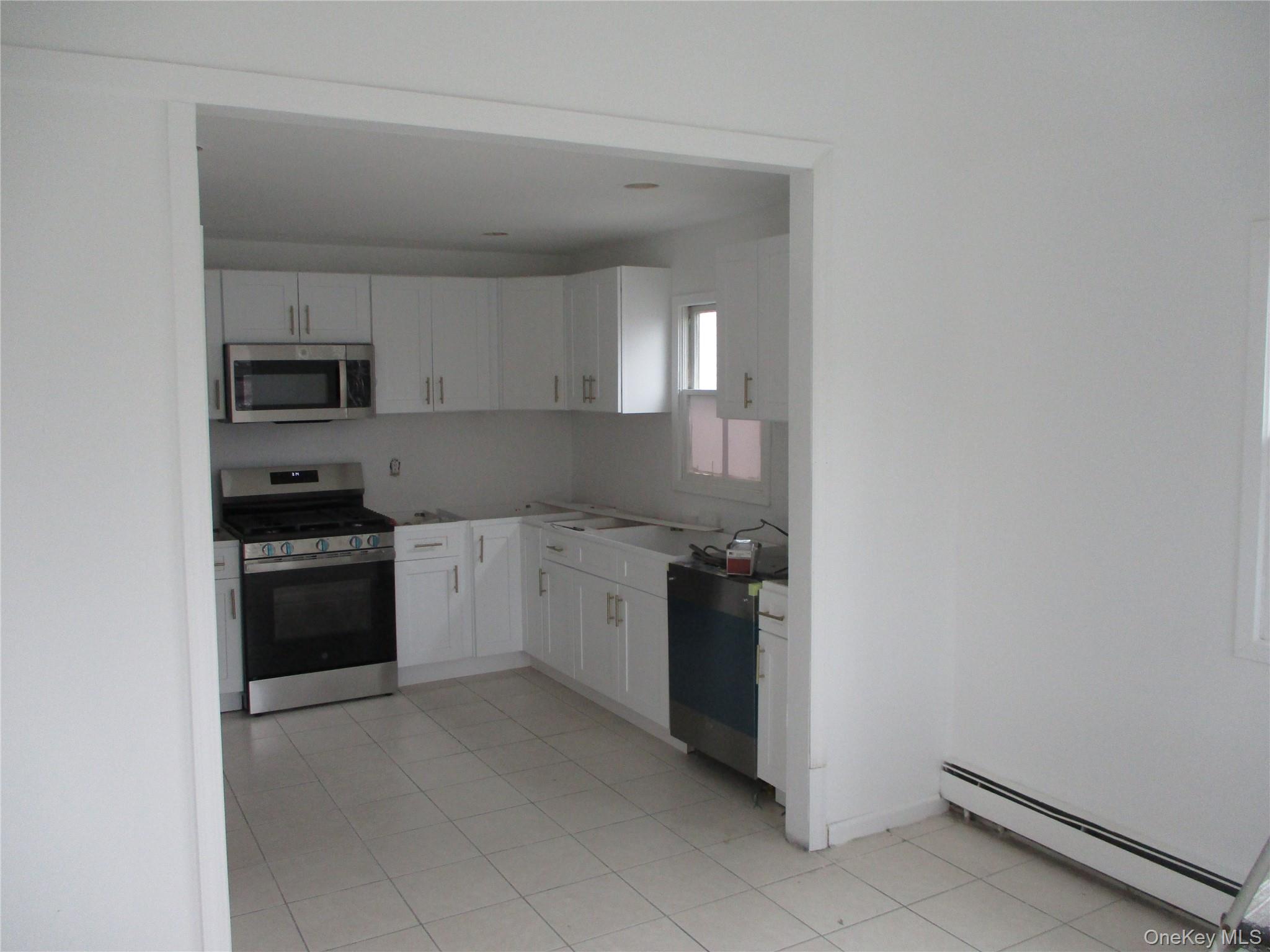 94 Roger Avenue Inwood, NY 11096 - Photo 3 of 19 a kitchen with a sink and a stove top oven