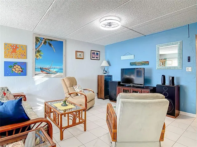 a living room with furniture a window and a flat screen tv