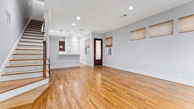 a view of a hallway with wooden floor and staircase
