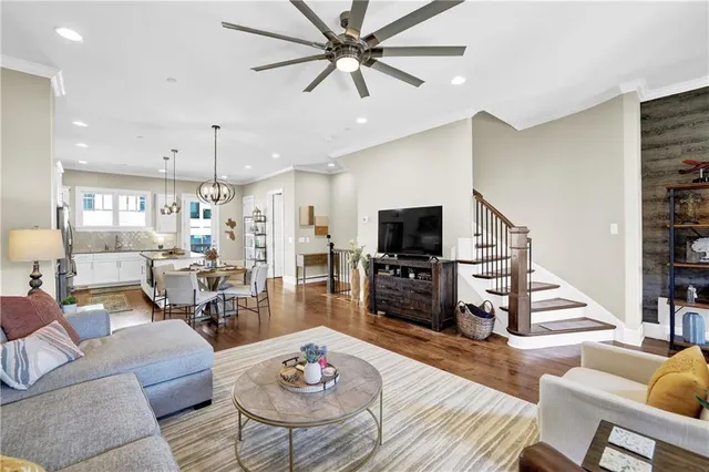 a living room with furniture kitchen view and a flat screen tv