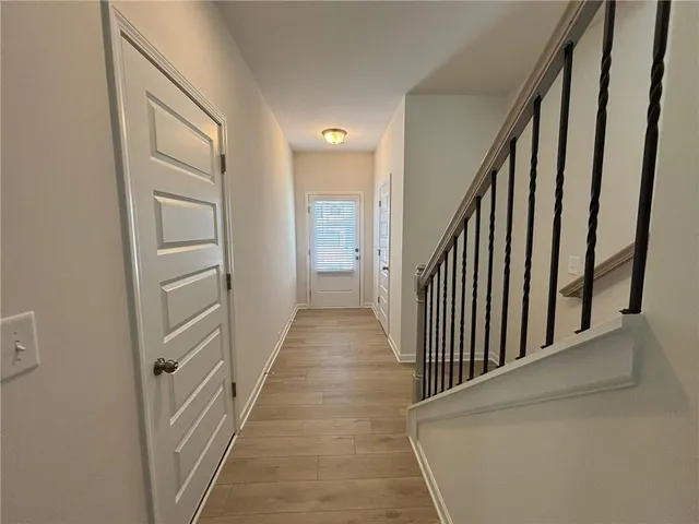 a view of a hallway with wooden floor and staircase