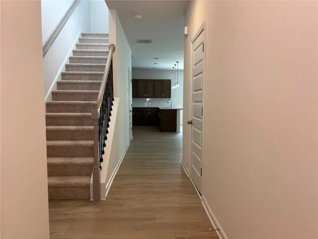a view of a hallway to a house with wooden floor and entryway