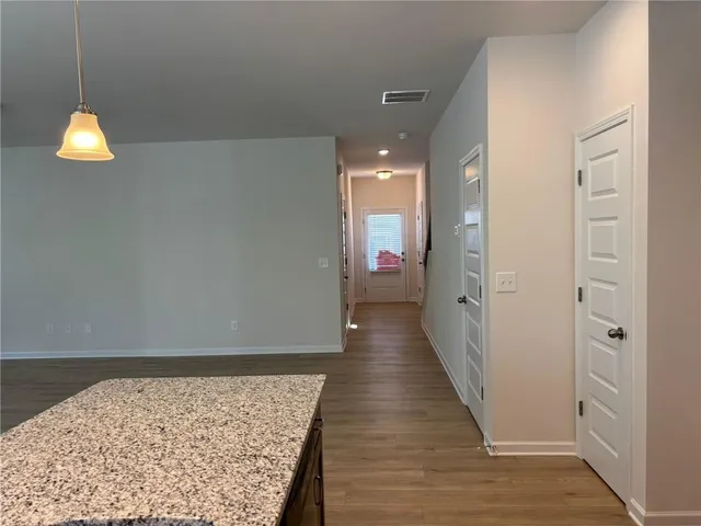 a open kitchen with stainless steel appliances granite countertop a sink dishwasher a stove and a refrigerator with wooden floor