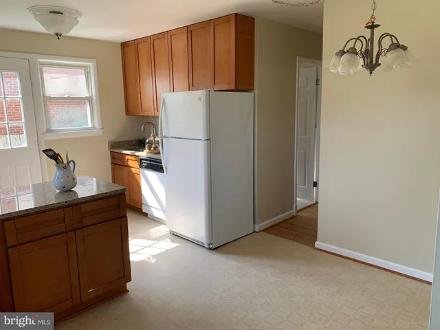 a kitchen with cabinets a refrigerator and a sink